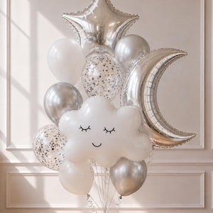 May include: A balloon bouquet featuring a large silver star, a silver crescent moon, and a white cloud balloon with a printed sleeping face. The arrangement includes additional round balloons in solid white, solid silver, and clear with silver confetti.