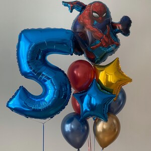 Puede incluir: Un globo azul con el n&uacute;mero 5, un globo Spiderman rojo y azul, un globo estrella dorado, un globo estrella azul, un globo azul oscuro y un globo dorado.