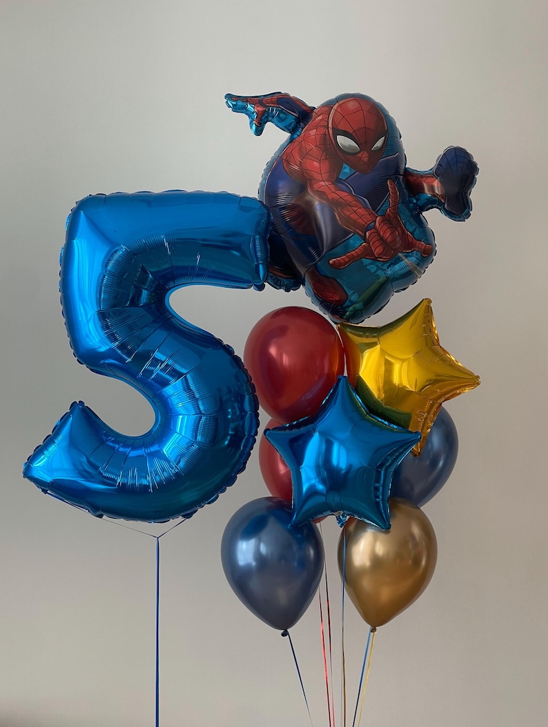 Puede incluir: Un globo azul con el n&uacute;mero 5, un globo Spiderman rojo y azul, un globo estrella dorado, un globo estrella azul, un globo azul oscuro y un globo dorado.