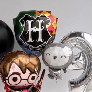 May include: A set of Harry Potter themed balloons, including a silver number 9 balloon, a silver balloon shaped like an owl, a brown balloon with a cartoon image of Harry Potter, and a black and gold balloon with the Hogwarts crest and the letter "H" in white.