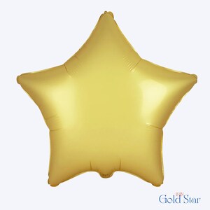 May include: A star-shaped foil balloon with a metallic gold finish. The balloon features a smooth, reflective surface and five distinct points. Printed text at the bottom right corner reads 18IN Gold Star, indicating a size of 18 inches.