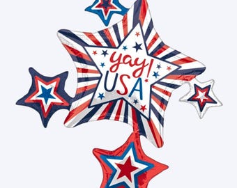 May include: A foil balloon cluster featuring a large central star with red, white, and blue sunburst stripes and the text "yay! USA" in red and blue script. Four smaller star-shaped balloons in red, white, and blue surround it. The text "35 INCH" is visible.