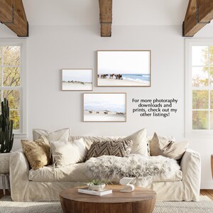 May include: Three framed landscape prints featuring horses on a beach and dunes. The prints are in light brown frames and hang on a white wall above a beige sofa. The text in the image says: For more photography downloads and prints, check out my other listings!