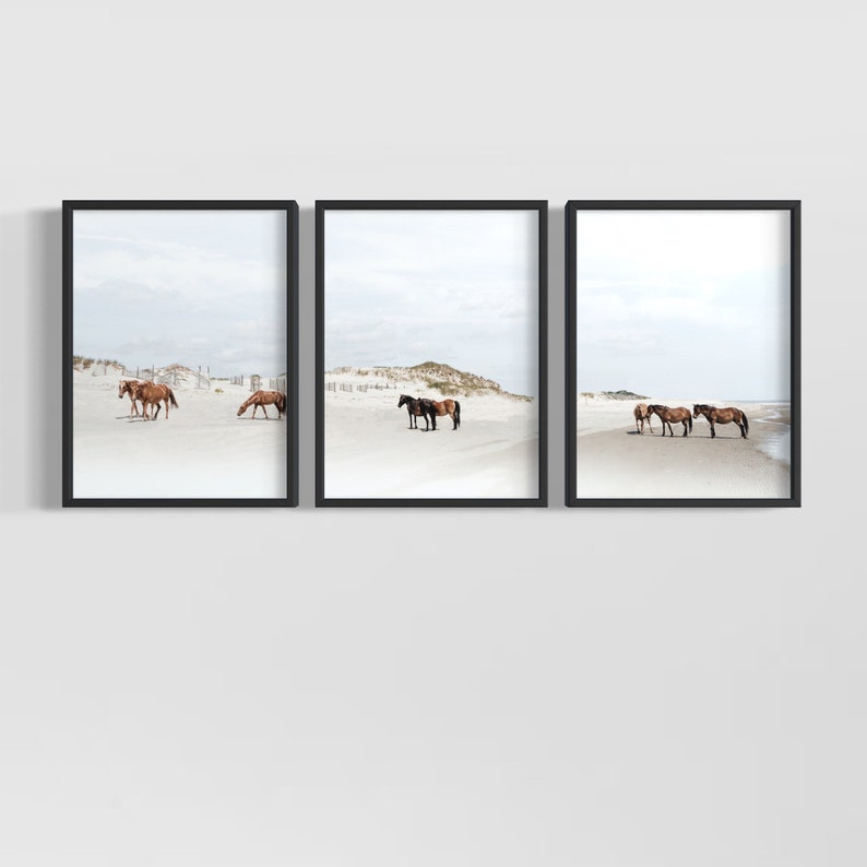 May include: A set of three framed prints featuring brown horses on a white sandy beach. The horses are standing and walking on the beach, with the ocean in the background.