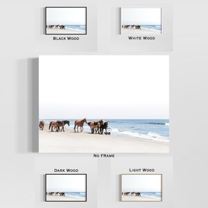May include: A framed print featuring a serene beach scene with a herd of wild horses. The horses, in shades of brown and black, are gathered near the water's edge. The print is available in black, white, dark, and light wood frames, as well as unframed.