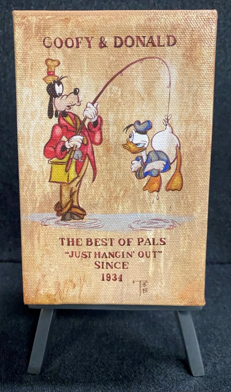 May include: Canvas art featuring Goofy and Donald Duck fishing. The artwork includes the text "GOOFY & DONALD" and "THE BEST OF PALS - JUST HANGIN' OUT SINCE 1934". The characters are depicted in their classic outfits, with Goofy holding the fishing rod.