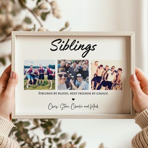 May include: A framed print with the word "Siblings" in a handwritten font. The print includes three photo collages and the text "Siblings by blood, best friends by choice." The names Chris, Steve, Charlie, and Mark are also written on the print.