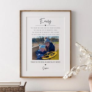 May include: A framed vertical wall art print featuring the name Emily at the top, a central photograph of a person and a child in a blue hat playing on a yellow toy, and the text Thank you for being an amazing key worker with the name Sophia.