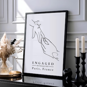 Minimalist line art print of two hands with an engagement ring, personalised with couple's names in handwritten script and custom engagement date and location beneath.