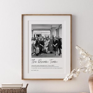 Può includere: Una fotografia in bianco e nero di un gruppo di persone in piedi davanti a un edificio. La foto è incorniciata in una cornice di legno e ha il testo "The Dream Team" e "Housekeeping Management Team 2023" scritto sotto la foto. Il testo sotto la foto dice: "Un team come voi è così speciale e così raro che volevo solo ringraziarvi."