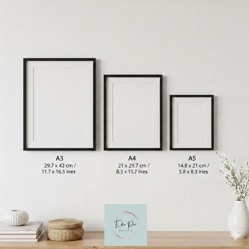 May include: Three framed art prints in black frames, labeled A3 (11.7 x 16.5 inches), A4 (8.3 x 11.7 inches), and A5 (5.8 x 8.3 inches). The prints are displayed on a white wall above a wooden surface. A small sign with the text "Ehe Pie" is visible.