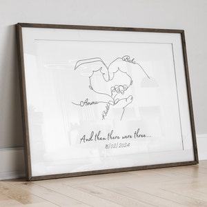 Newborn keepsake print displaying overlapping hands of parents and baby, customized with family details.