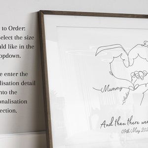 May include: A black and white line art print of two hands forming a heart shape with the words "Mummy", "Archie", and "Daddy" written underneath. The text "And then there were three... 09th May 2024" is at the bottom of the print.
