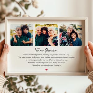 May include: A framed photo collage with three family photos and the text "To our Grandson." The frame is held by a person. The text includes a loving message from Grandma and Grandad.