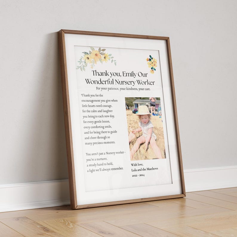 May include: Framed print with a wooden frame. The print features text that reads "Thank you, Emily Our Wonderful Nursery Worker" with a photo of a child. Floral accents in yellow and green decorate the top corners.