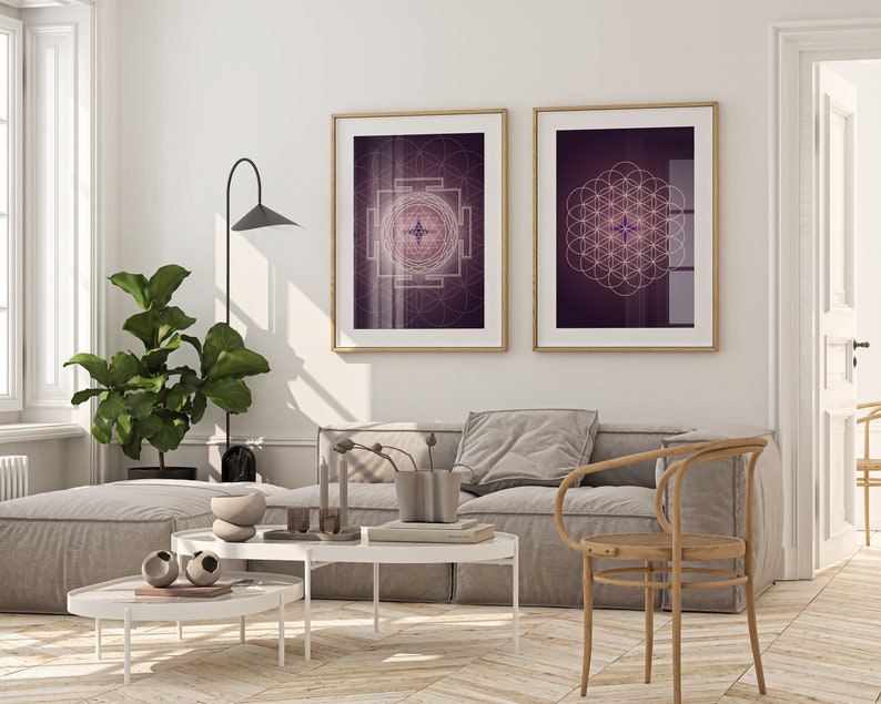 Pu&ograve; includere: Due stampe incorniciate di disegni geometrici in bianco su sfondo viola sono appese a una parete bianca sopra un divano grigio e una sedia di legno. I disegni sono un quadrato con una stella al centro e un cerchio con un motivo a fiore della vita.
