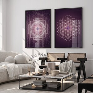 Pu&ograve; includere: Due stampe incorniciate con disegni geometrici su sfondo viola. La stampa a sinistra presenta un disegno geometrico bianco con una stella al centro. La stampa a destra presenta un disegno bianco della fioritura della vita con una stella al centro.