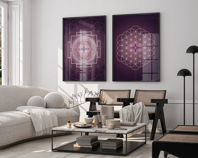 Pu&ograve; includere: Due stampe incorniciate con disegni geometrici su sfondo viola. La stampa a sinistra presenta un disegno geometrico bianco con una stella al centro. La stampa a destra presenta un disegno bianco della fioritura della vita con una stella al centro.