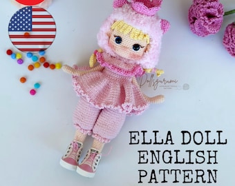May include: A pink crocheted doll with blonde hair wearing a pink dress, white shoes, and a pink and white hat. The doll is sitting on a white surface with the text "Ella Doll English Pattern" below it.
