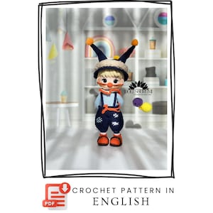 May include: A handmade crochet doll wearing a blue and white checkered shirt, navy blue overalls, and orange shoes. The doll has a beige hat with orange pom-poms. The image includes the text "CROCHET PATTERN IN ENGLISH".