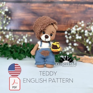 以下が含まれることがあります： オーバーオールを着て、ハチミツの瓶を持っているテディベアのための編み物パターン。パターンは英語で入手可能で、PDF形式のデジタルダウンロードです。パターンは、約25cmの小さなテディベア用です。