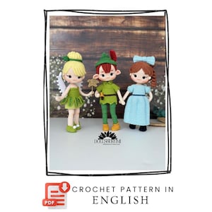 Könnte beinhalten: Häkelanleitung mit drei handgefertigten Puppen: eine Fee, Peter Pan und Wendy. Die Puppen tragen grüne, blaue und gelbe Outfits. Der Text "CROCHET PATTERN IN ENGLISH" ist ebenfalls sichtbar.