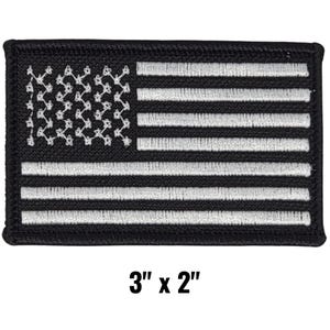 May include: A rectangular black and white embroidered patch featuring the American flag design. The patch measures 3 inches by 2 inches. The stars are white, and the stripes are white on a black background.