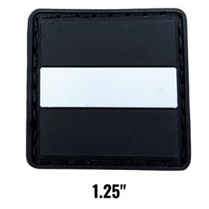 May include: A square black patch with a white horizontal stripe, measuring 1.25 inches. The patch has a textured border and is set against a white background. The text "1.25" is displayed below the patch.