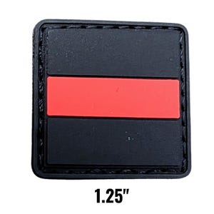 May include: A square, black patch with a red horizontal stripe across the center. The patch is 1.25 inches wide and has a stitched border. The text "1.25" is displayed in black at the bottom.