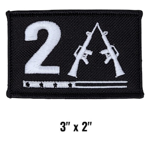 May include: Black rectangular patch with white embroidered design. Features the number "2" and two rifles crossed in an "X" shape. Below the rifles is a horizontal line with stars. The patch measures 3 inches by 2 inches.