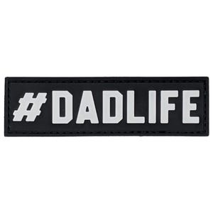 May include: A rectangular black patch with the white text "#DADLIFE". The patch has a textured appearance and is designed to be attached to clothing or gear. The text is in a bold, sans-serif font.