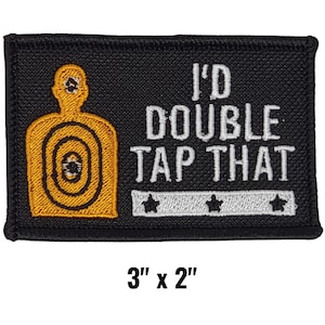 May include: Black embroidered patch with the text "I'd DOUBLE TAP THAT" in white. The patch features a gold target silhouette and measures 3" x 2".