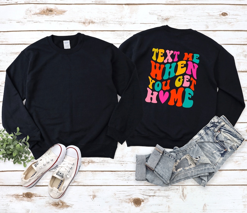 May include: Black sweatshirt with the text "Text Me When You Get Home" in colourful retro font with a pink heart.