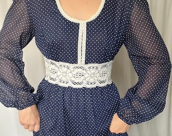 May include: A navy blue maxi dress with white polka dots and a white lace trim around the neckline and waist.