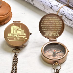 May include: A brass compass with a truck design on the lid. The compass has a chain and is engraved with the name "ALEX". The compass is open and the inside has a poem about safe travels. The poem reads: "Lord, please help me to be Safe as I travel each mile. Let your presence guide me and bring me a smile. Take care of my family while I am away. Let them know I miss them each and every day. Steer me clear of danger as I drive these miles alone. I put my hands in yours, Lord. KEEP ME SAFE GET ME HOME"