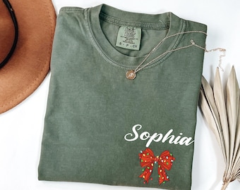 Comfort Colors® Personalized Name Christmas Bow T-Shirt, Xmas Holiday Shirt, Coquette Christmas Lights Tee
