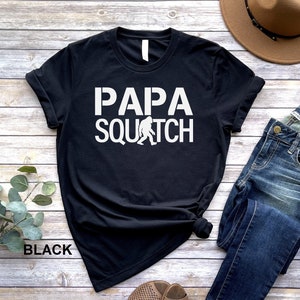 May include: Black t-shirt with white text that reads "Papa Squatch" and a small graphic of a Bigfoot.
