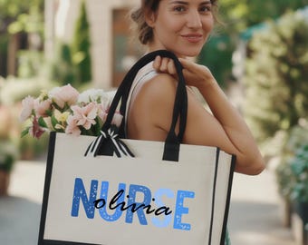 May include: A canvas tote bag with black handles and a black bottom panel. The bag features the word "NURSE" in blue letters, with the name "olivia" in cursive below. The bag is filled with pink and white flowers.