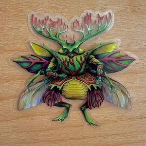 Puede incluir: Una pegatina colorida con una ilustración detallada de una criatura parecida a un escarabajo. El diseño incorpora tonos verdes, amarillos, rojos y morados, con patrones intrincados y texto. La criatura tiene grandes alas y un cuerpo segmentado.