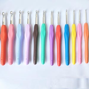 Peut inclure: Un ensemble de 12 crochets à crochet colorés avec des poignées ergonomiques. Les crochets sont en métal et ont différentes tailles, allant de 3,5 mm à 10 mm. Les crochets sont parfaits pour crocheter une variété de projets, des petits amigurumi aux grandes couvertures.