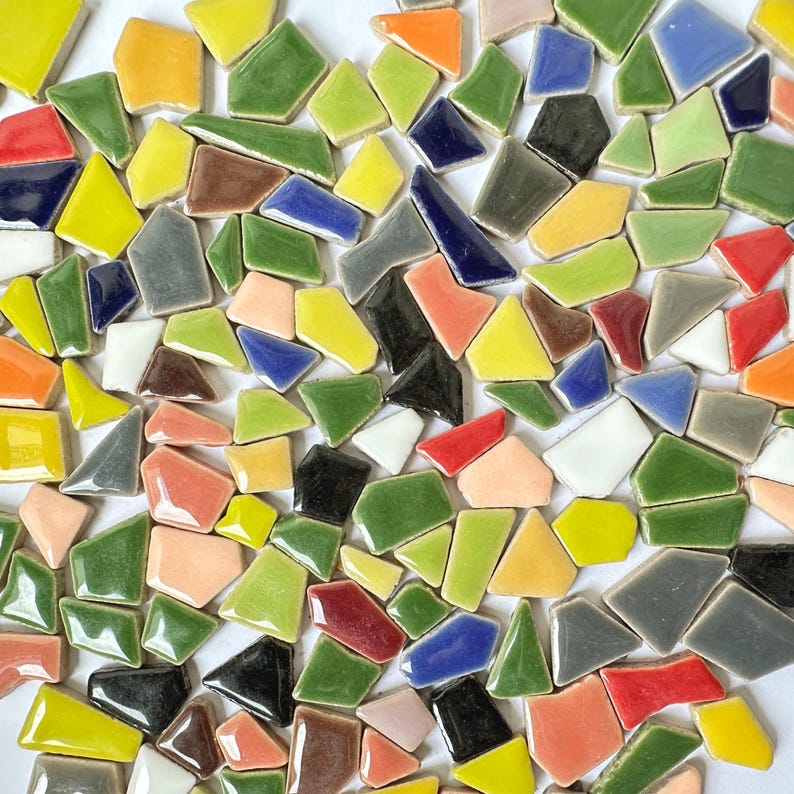 Puede incluir: Una colecci&oacute;n de azulejos cer&aacute;micos de colores y formas irregulares en varios tonos de verde, azul, rojo, amarillo, naranja y blanco. Los azulejos est&aacute;n dispuestos en un patr&oacute;n aleatorio, creando un efecto de mosaico.