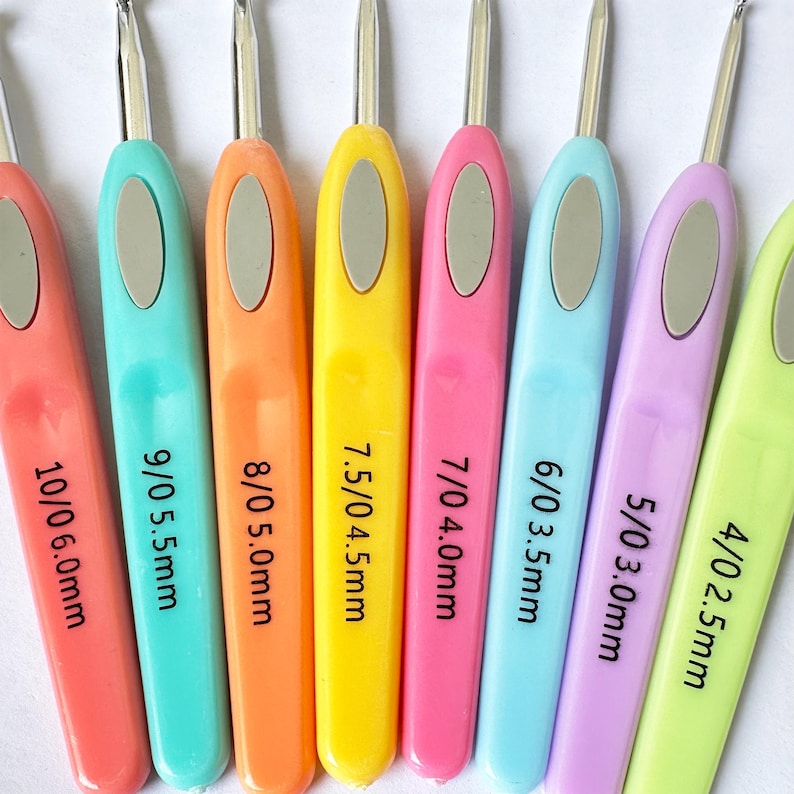 May include: A set of 10 crochet hooks in various sizes, ranging from 2.5mm to 6.0mm. The hooks are colour-coded and labelled with their size and corresponding UK size. The hooks are made of plastic and have a smooth finish.