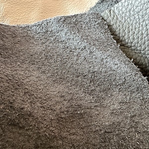 May include: Close-up of two different types of leather. One is a smooth, dark brown leather, and the other is a light brown suede leather.