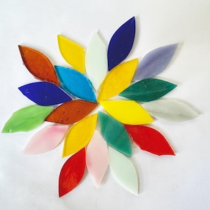 May include: A collection of 18 colorful glass leaf-shaped tiles arranged in a circular pattern. The tiles are in various shades of blue, green, yellow, orange, red, and pink.