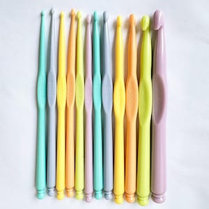 Op de afbeelding: Een set van 10 kleurrijke haaknaalden in verschillende maten, variërend van 2,5 mm tot 10,00 mm. De haaknaalden zijn gemaakt van plastic en hebben een gladde afwerking.