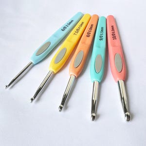 May include: Set of five colourful crochet hooks with silver metal tips. The hooks are labelled with their sizes: 6/0 3.5mm, 7.5/0 4.5mm, 8/0 5.0mm, 9/0 5.5mm, and 10/0 6.0mm.