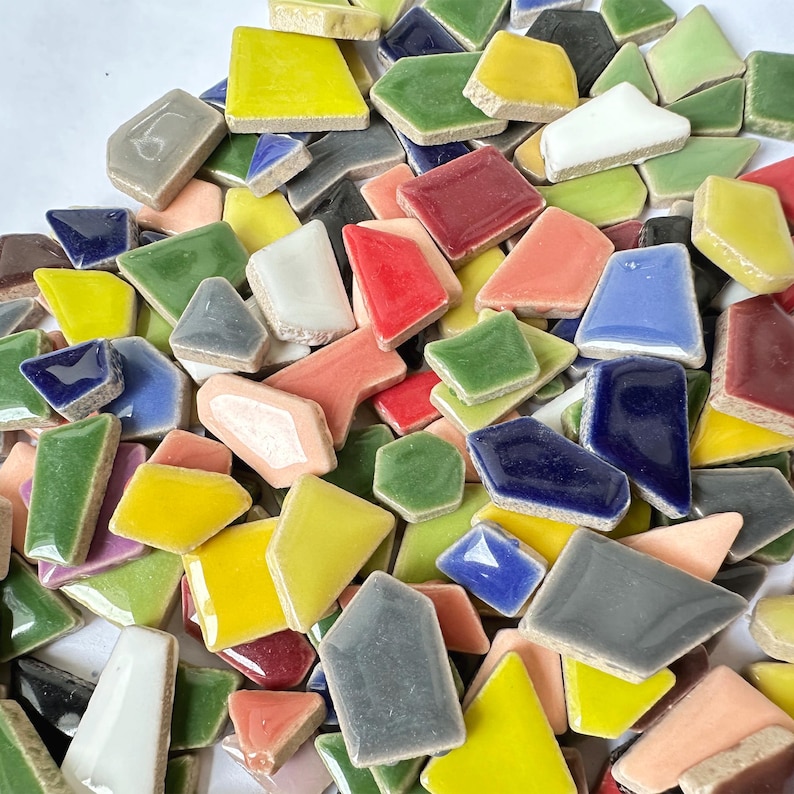 Puede incluir: Una colecci&oacute;n de azulejos de cer&aacute;mica de colores vivos y formas irregulares. Los azulejos son de varios tonos de azul, verde, amarillo, rojo y rosa. Son perfectos para proyectos de manualidades y mosaicos.