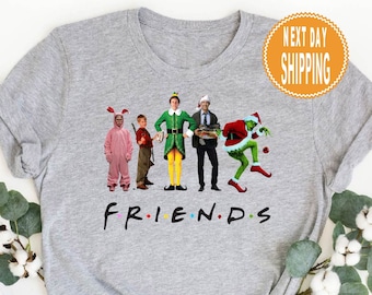 May include: A gray t-shirt with a graphic of characters from popular Christmas movies. The characters are standing in a line and the text "FRIENDS" is below them.