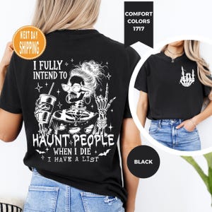K&ouml;nnte beinhalten: Schwarzes T-Shirt mit einem wei&szlig;en Skelett-Motiv, das eine Brille tr&auml;gt, ein Getr&auml;nk h&auml;lt und eine Rock-Geste macht. Der Text lautet: "I FULLY INTEND TO HAUNT PEOPLE WHEN I DIE I HAVE A LIST."