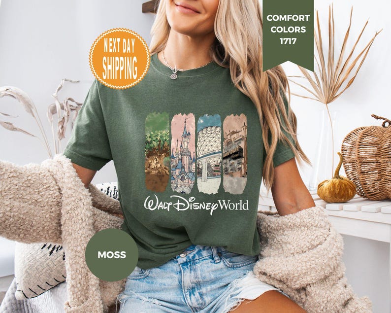 May include: Moss green t-shirt featuring four rectangular panels with Disney World imagery and the words "Walt Disney World" in white. The shirt has a crew neck and short sleeves. The shirt is a Comfort Colors 1717.